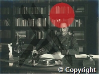 Ross in uniform, seated behind desk	