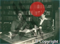 Ross seated at his desk with woman